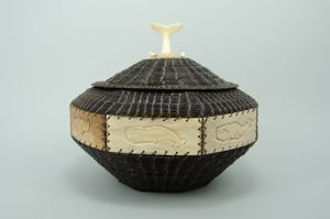 Image of large baleen basket on wood frame, decorative bone tiles, whale's tail finial